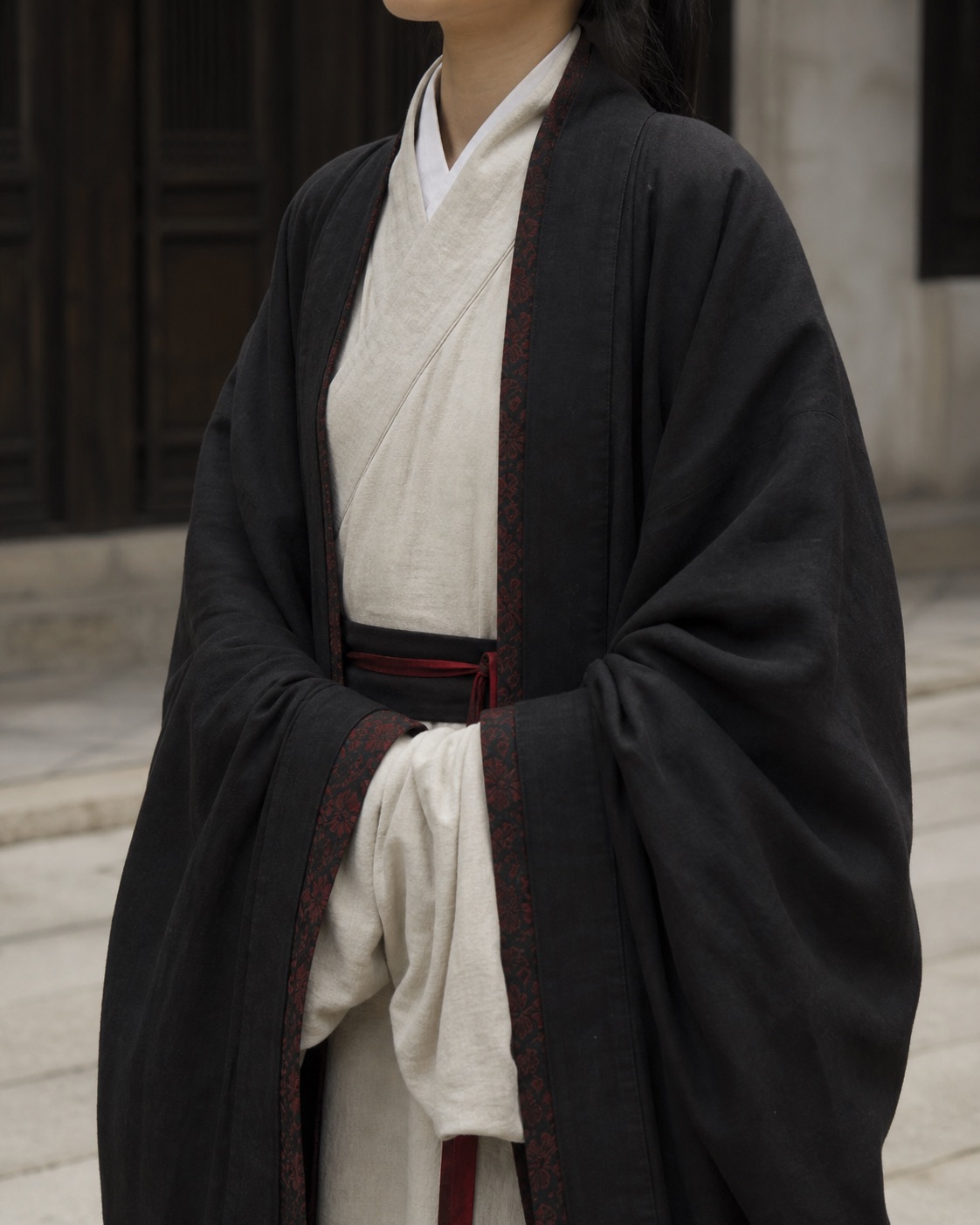 Layered black and ivory hanfu with restrained red trim.