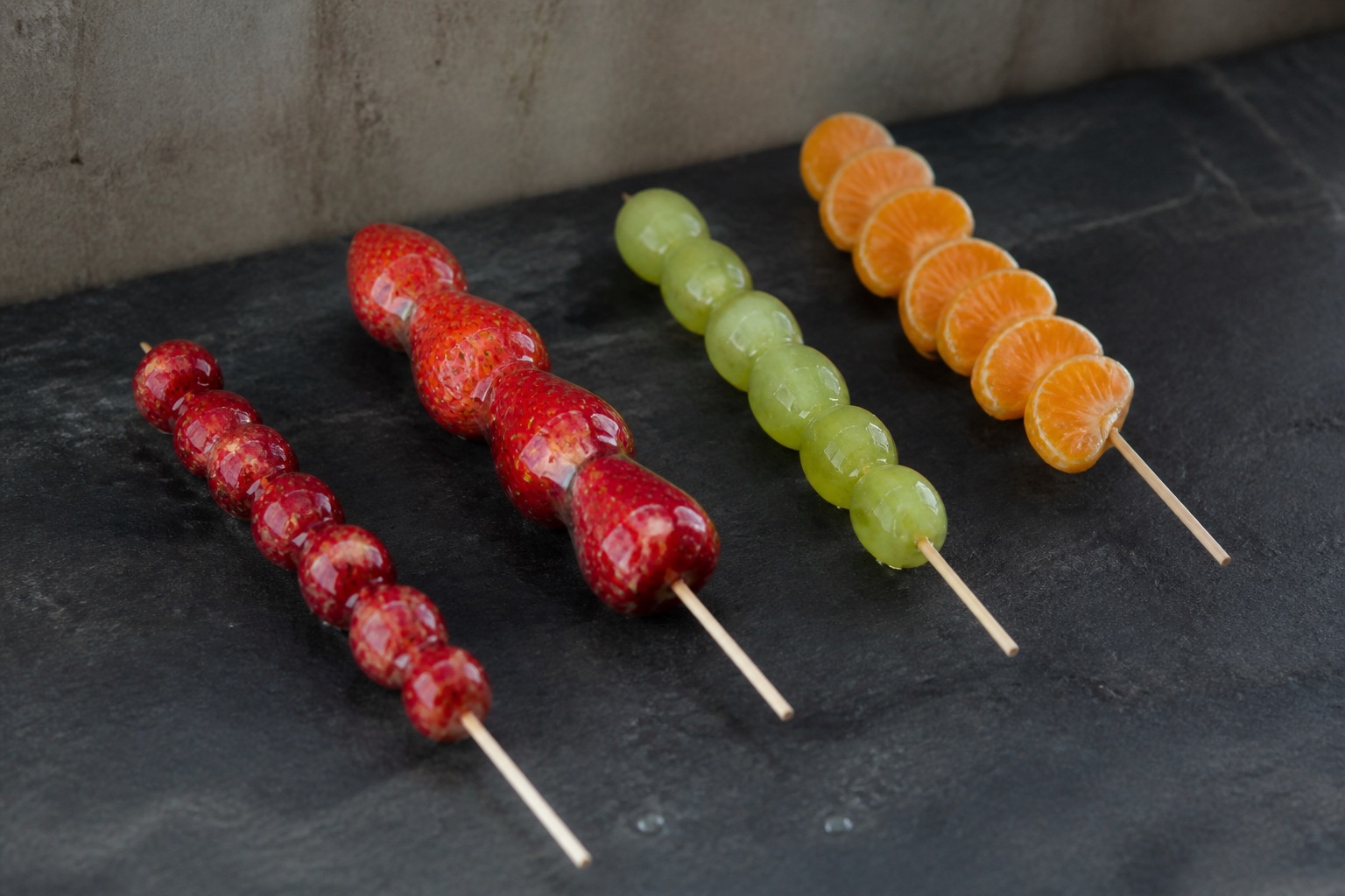 Tanghulu-inspired skewers made with hawthorn, strawberries, grapes, and citrus.